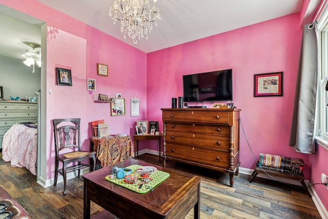 living room with wood-type flooring and ceiling fan with notable chandelier