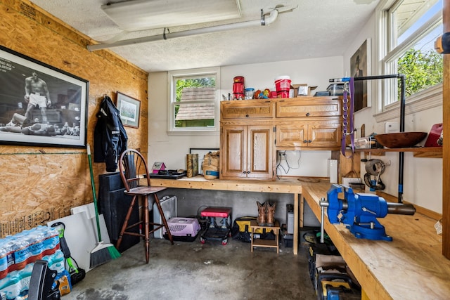 misc room with concrete floors, a workshop area, and a textured ceiling