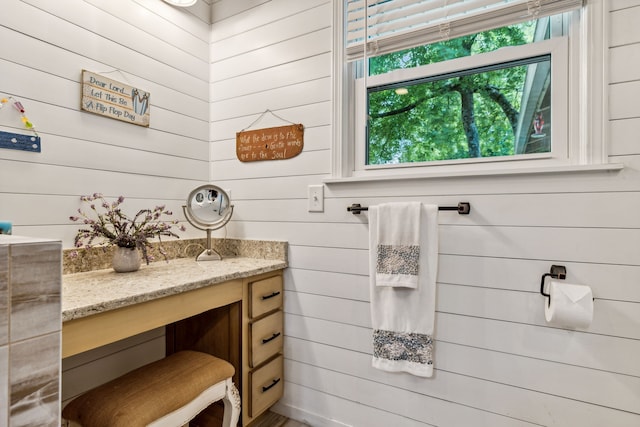 bathroom with vanity and wood walls