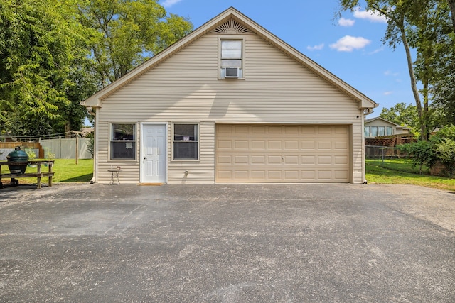 view of front of home with cooling unit, a front lawn, and a garage