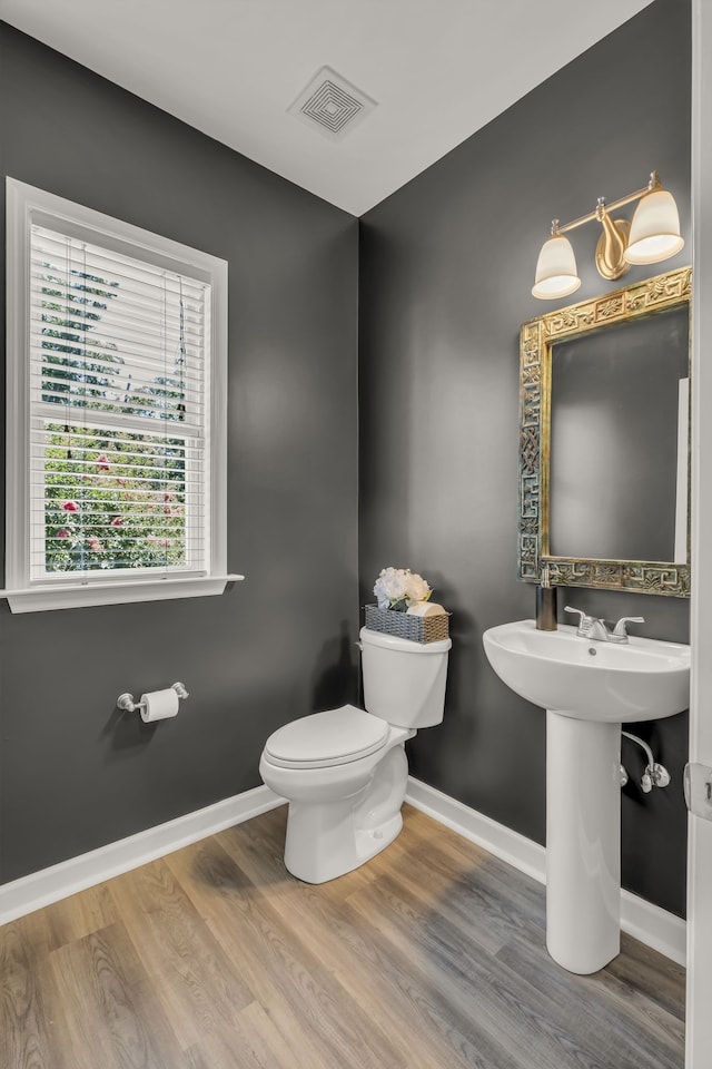 bathroom featuring toilet and wood-type flooring