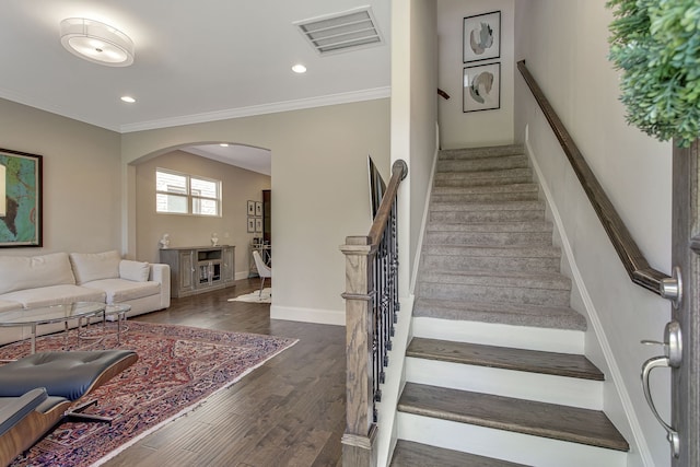 staircase with crown molding and hardwood / wood-style floors