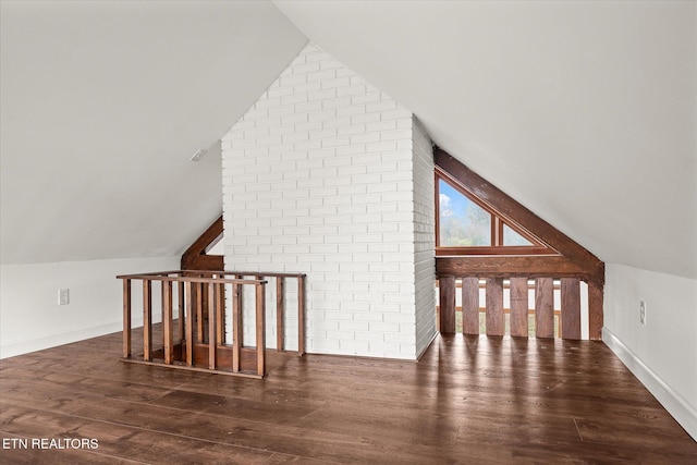 additional living space with dark wood-type flooring and vaulted ceiling