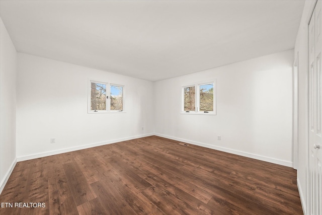 spare room with dark hardwood / wood-style floors