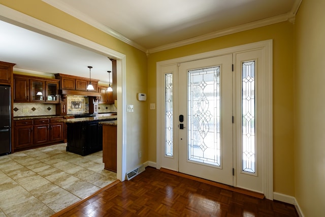 entrance foyer with crown molding, light parquet flooring, and a wealth of natural light