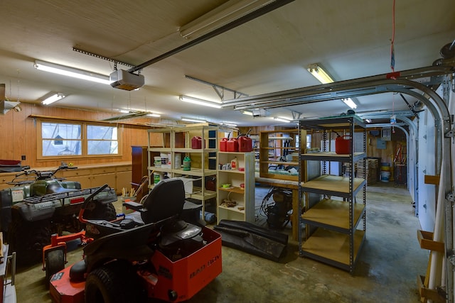 garage featuring wood walls and a garage door opener