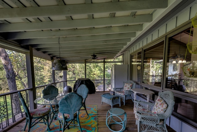 sunroom with lofted ceiling with beams and ceiling fan