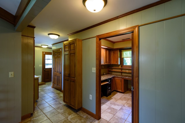 hall with crown molding and wooden walls