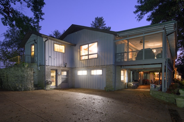 back house at dusk featuring a patio area