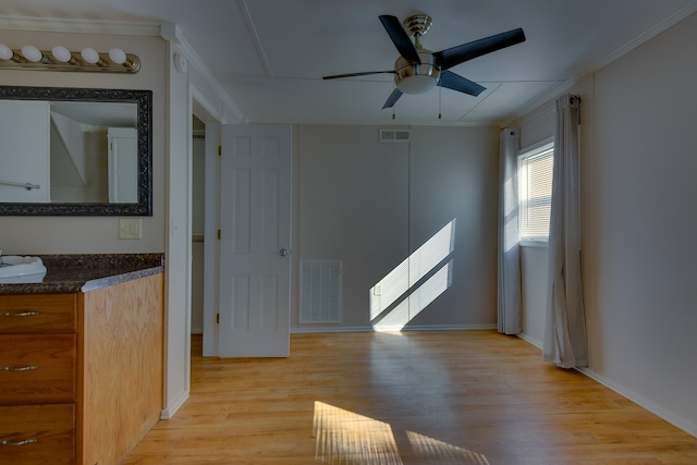 interior space with crown molding, light wood-type flooring, and ceiling fan