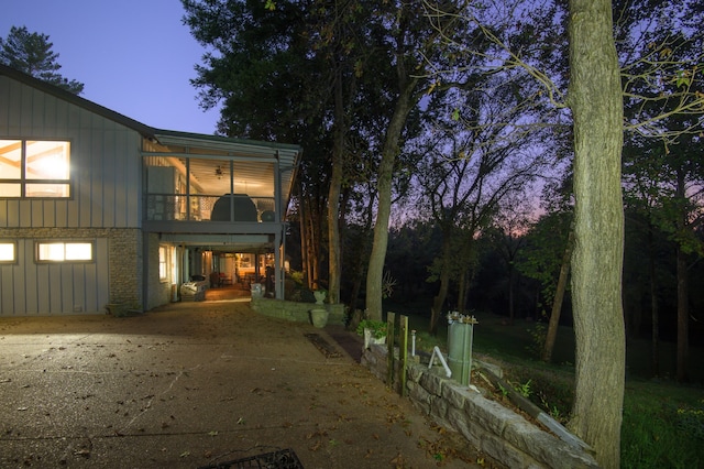 property exterior at dusk featuring a balcony