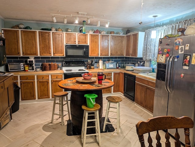 kitchen with a kitchen breakfast bar, backsplash, black appliances, crown molding, and a textured ceiling