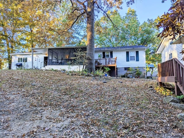 rear view of house with a deck and a sunroom