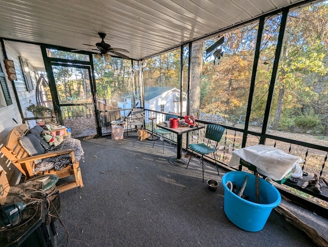 unfurnished sunroom with ceiling fan