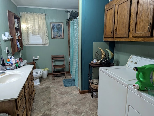 washroom with ornamental molding, sink, and separate washer and dryer