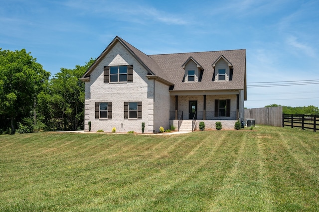 view of front of house with central AC and a front lawn