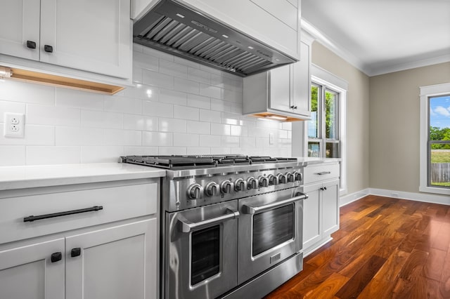 kitchen with dark wood finished floors, double oven range, custom exhaust hood, light countertops, and ornamental molding