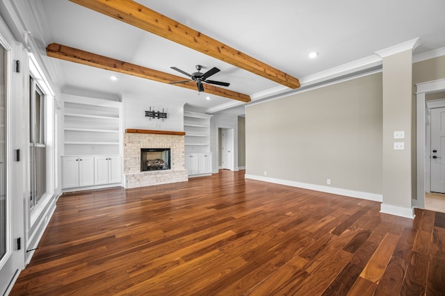 unfurnished living room with beamed ceiling, a brick fireplace, and dark hardwood / wood-style floors