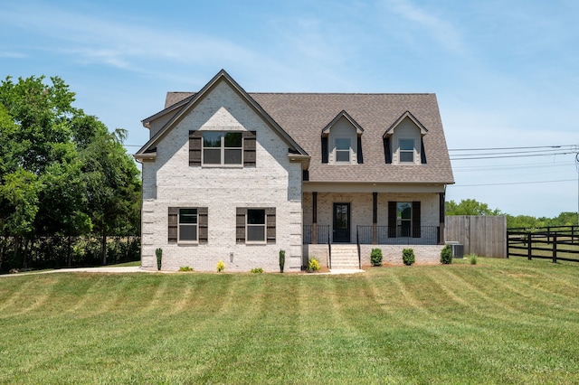 view of front of home with a front lawn and central AC