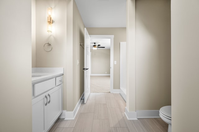 bathroom with vanity, toilet, and ceiling fan