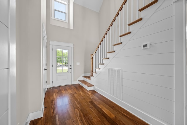 entryway with a towering ceiling and dark hardwood / wood-style floors