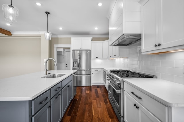 kitchen with white cabinets, custom range hood, stainless steel appliances, sink, and decorative light fixtures