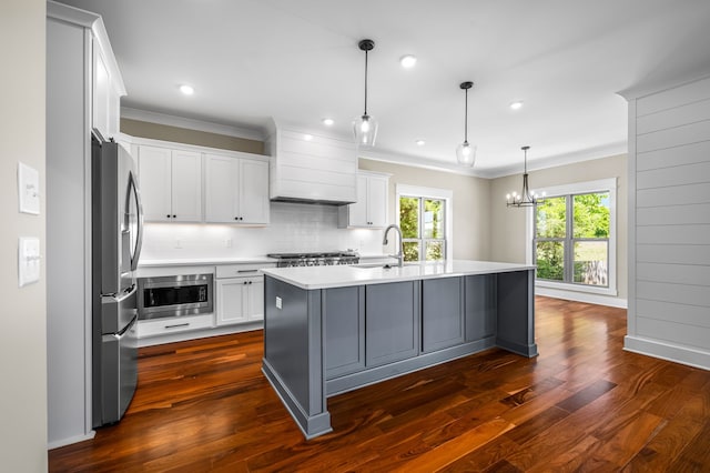 kitchen featuring white cabinets, stainless steel appliances, dark hardwood / wood-style floors, and a kitchen island with sink