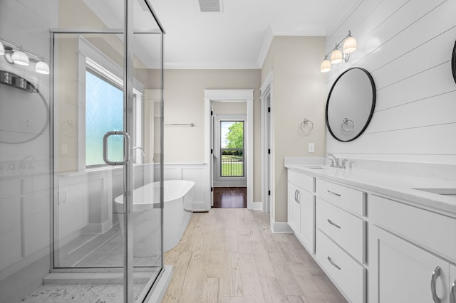 bathroom with vanity, hardwood / wood-style flooring, a healthy amount of sunlight, and plus walk in shower