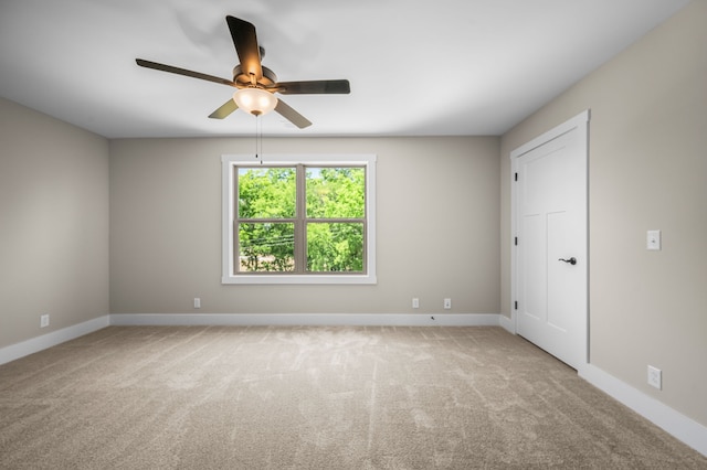 carpeted spare room featuring ceiling fan