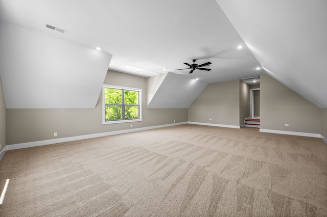 additional living space featuring light carpet, lofted ceiling, and ceiling fan