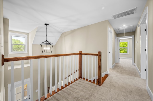 hall with lofted ceiling and light carpet