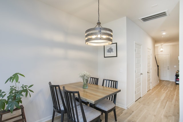 dining room featuring light hardwood / wood-style flooring and a notable chandelier