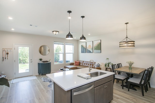 kitchen featuring light hardwood / wood-style flooring, stainless steel dishwasher, sink, and plenty of natural light