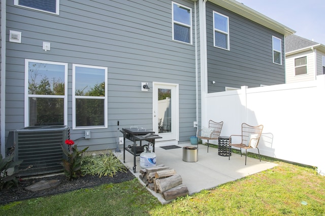 back of property featuring central air condition unit, a patio, and a lawn