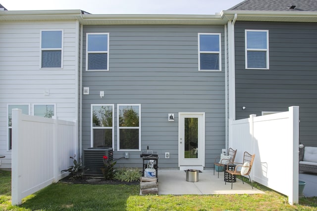 rear view of property featuring a lawn, a patio, and central AC unit