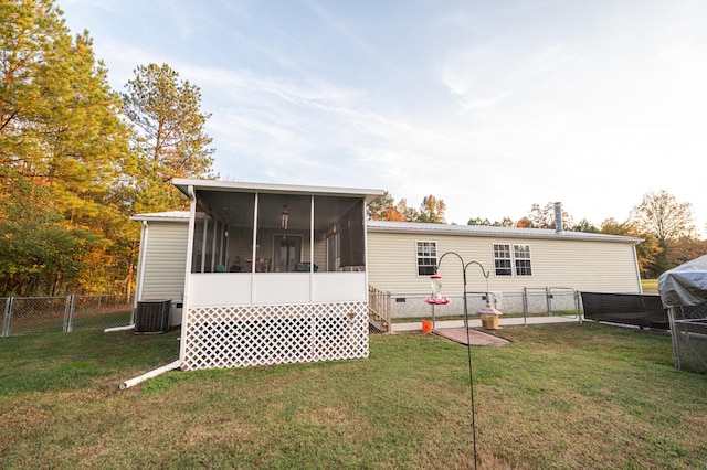 back of house featuring a yard, central AC unit, and a sunroom