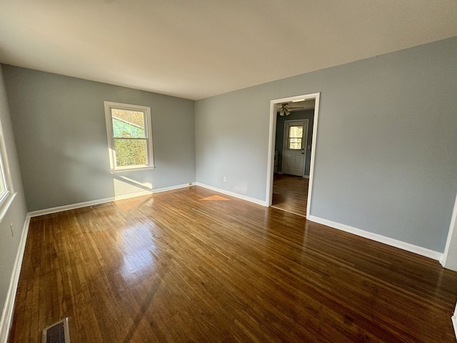 unfurnished room featuring dark wood-type flooring and ceiling fan