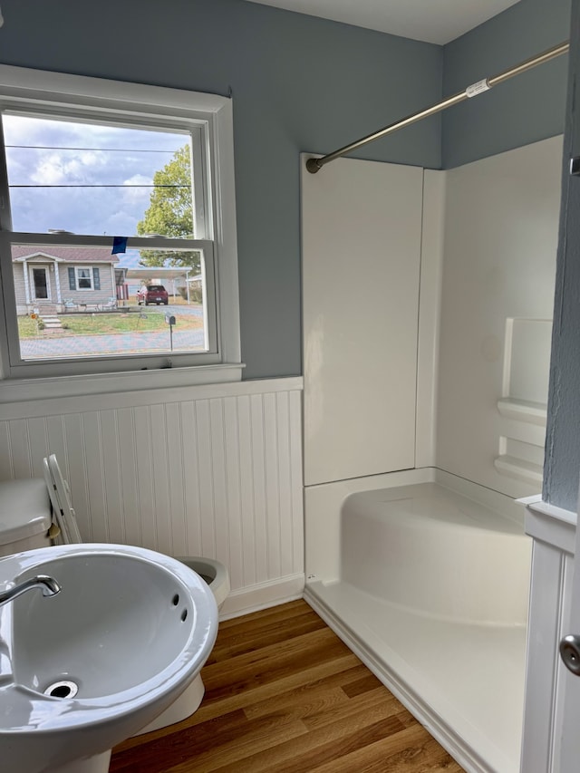 bathroom with toilet, hardwood / wood-style floors, and shower / bathtub combination