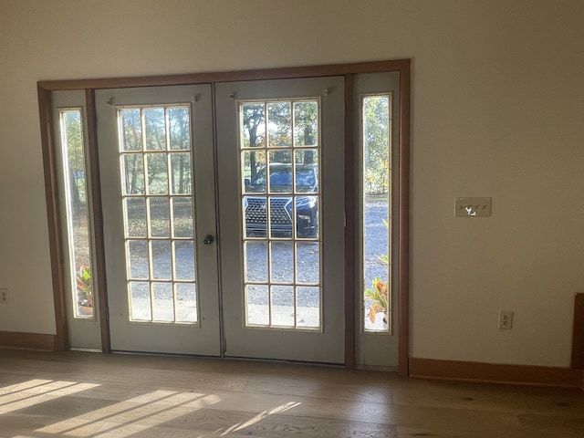 doorway with french doors and light hardwood / wood-style flooring