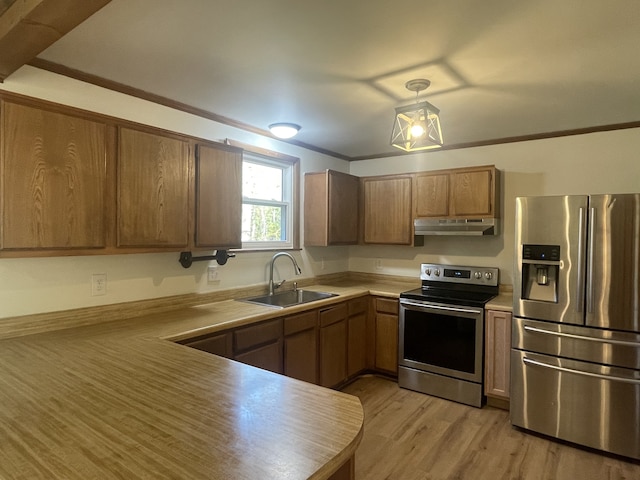 kitchen featuring stainless steel appliances, light hardwood / wood-style floors, sink, ornamental molding, and pendant lighting