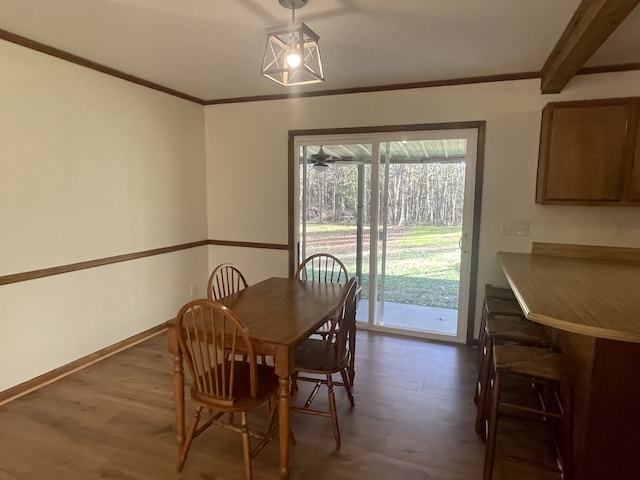 dining room with dark wood-type flooring and crown molding