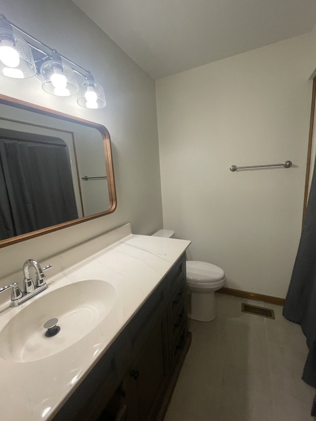 bathroom featuring tile patterned flooring, vanity, and toilet