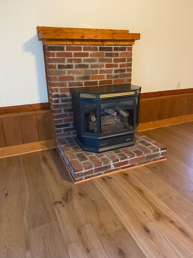 details with wooden walls, a wood stove, and hardwood / wood-style flooring