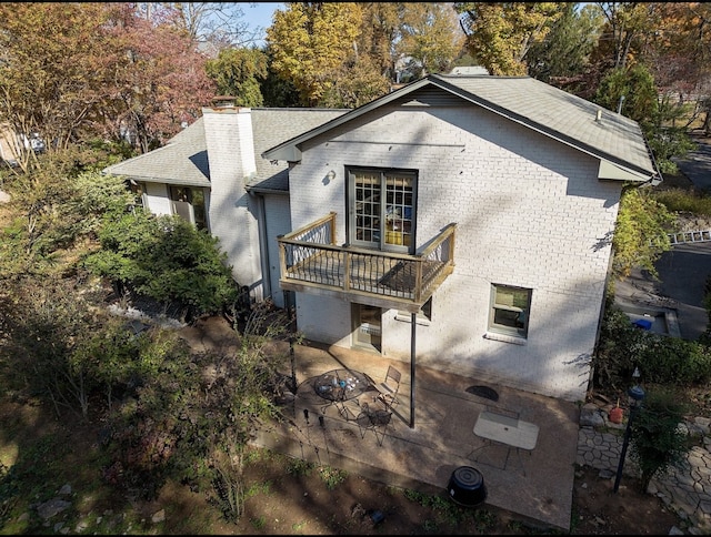 back of house with a wooden deck and a patio