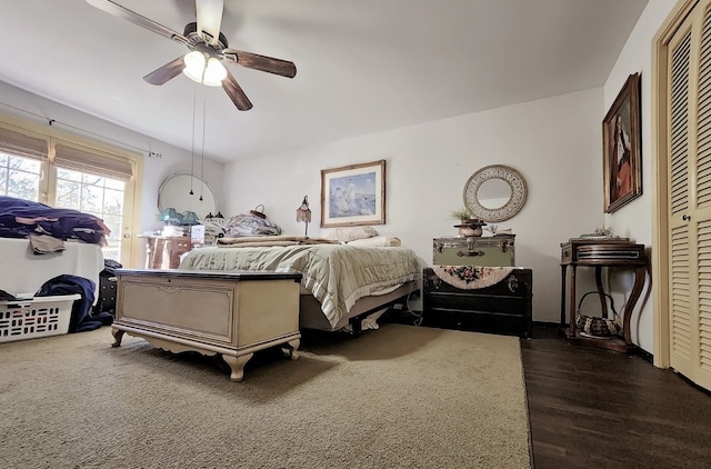 bedroom with dark hardwood / wood-style flooring, a closet, and ceiling fan