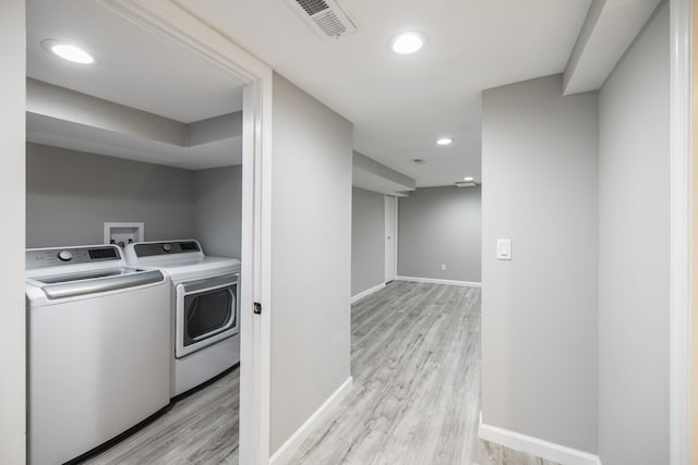 laundry area featuring light hardwood / wood-style flooring and washer and dryer