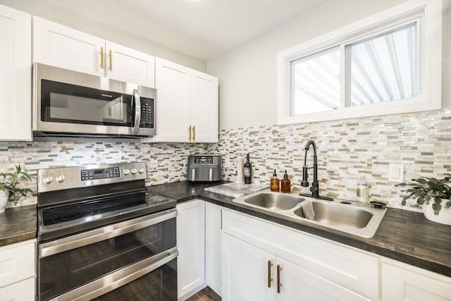 kitchen featuring backsplash, appliances with stainless steel finishes, sink, and white cabinets