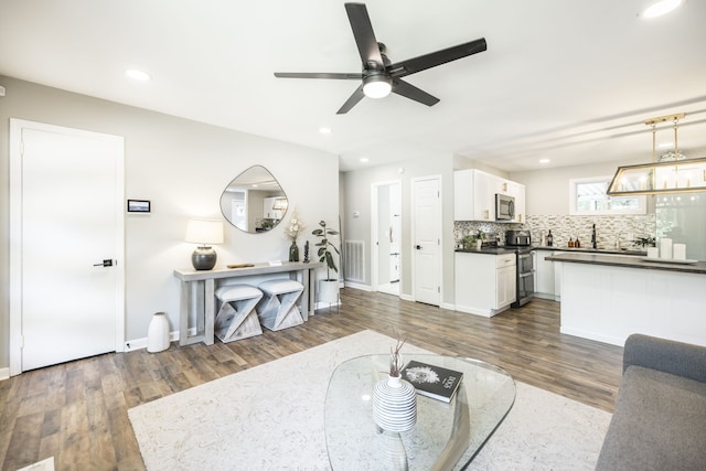 living room with dark wood-type flooring and ceiling fan