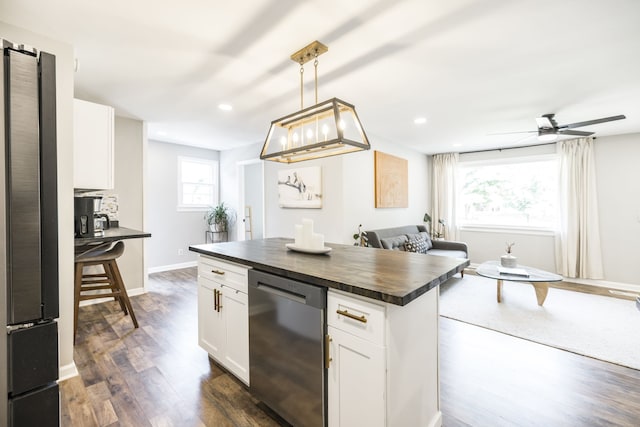 kitchen with appliances with stainless steel finishes, white cabinets, and a wealth of natural light