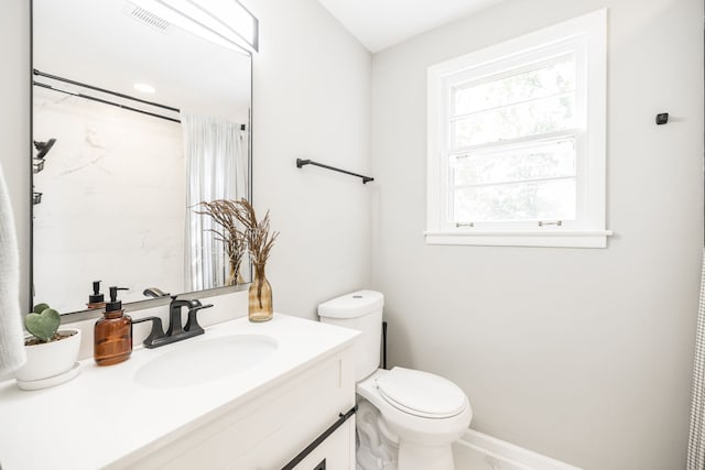 bathroom featuring vanity, toilet, and walk in shower